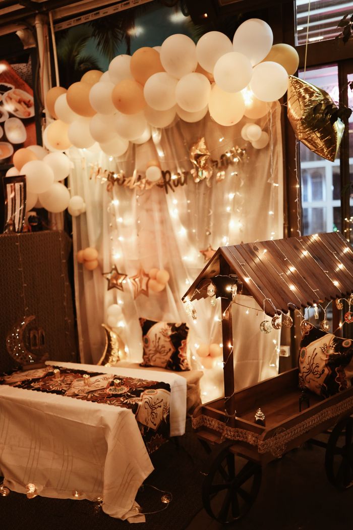 Festive indoor party decor with balloons and fairy lights creating a cozy ambiance.