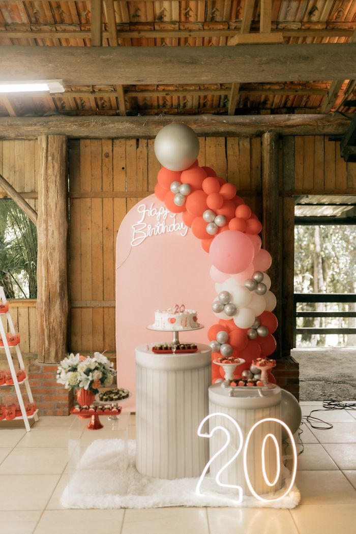Elegant indoor decor for a 20th birthday party with balloons and birthday cake.